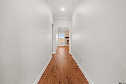 hallway featuring ornamental molding and hardwood / wood-style floors