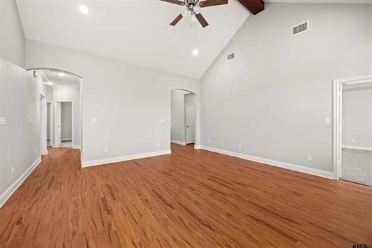 unfurnished living room featuring hardwood / wood-style floors, beam ceiling, high vaulted ceiling, and ceiling fan