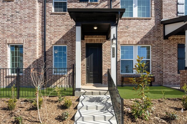 entrance to property featuring brick siding