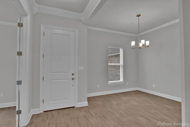 foyer featuring crown molding, a notable chandelier, and light wood-type flooring