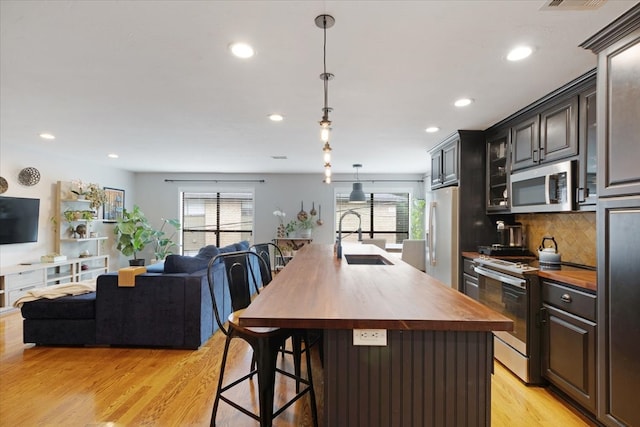 kitchen featuring wooden counters, a wealth of natural light, sink, and stainless steel appliances