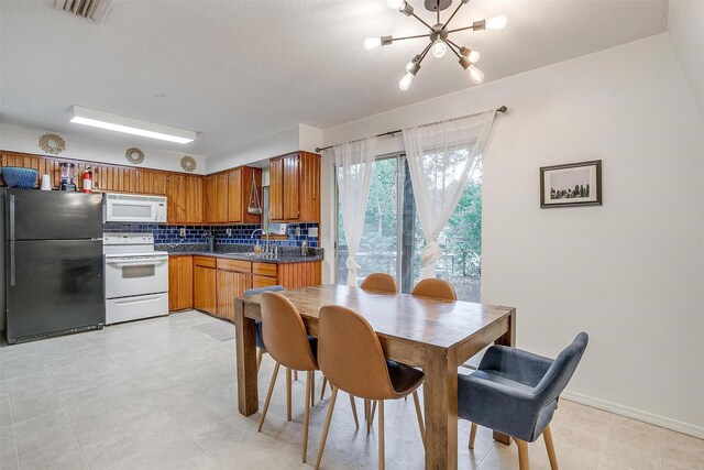 dining space featuring sink, light wood-type flooring, and ceiling fan