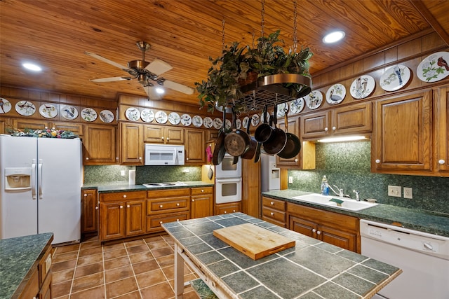 kitchen featuring white appliances, tasteful backsplash, sink, a center island, and tile patterned flooring