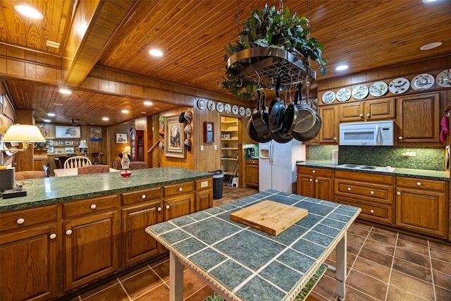 kitchen with a center island, white appliances, and wood walls