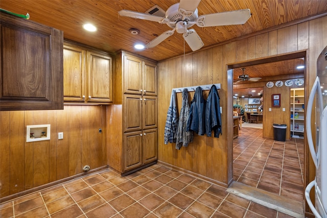 clothes washing area featuring hookup for a washing machine, wood walls, dark tile patterned floors, wooden ceiling, and cabinets