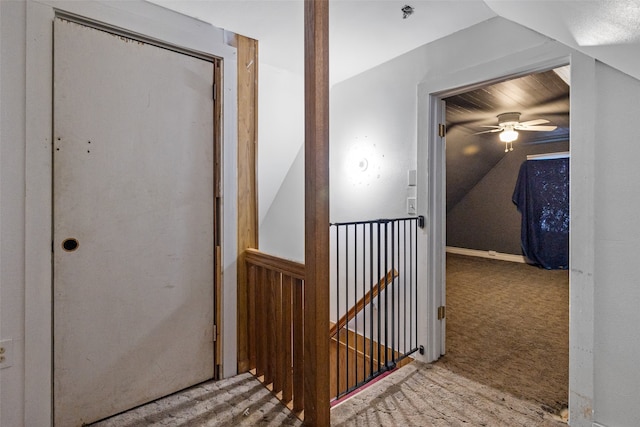 corridor featuring lofted ceiling and carpet flooring