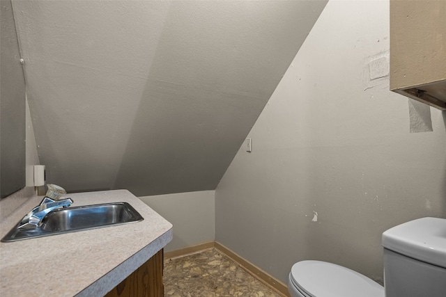 bathroom with vanity, toilet, and vaulted ceiling