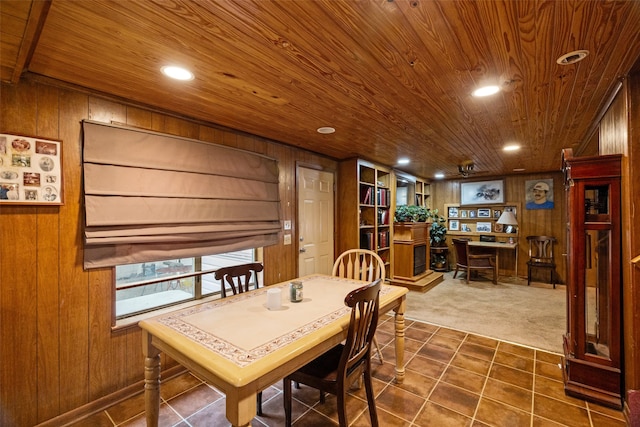 dining space with wooden walls, wooden ceiling, and dark colored carpet