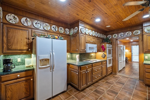 kitchen featuring tasteful backsplash, dark tile patterned floors, ceiling fan, and white appliances