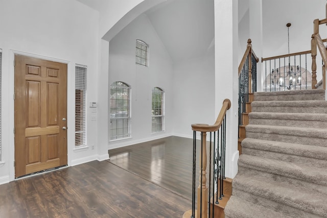 entryway with dark hardwood / wood-style floors and high vaulted ceiling