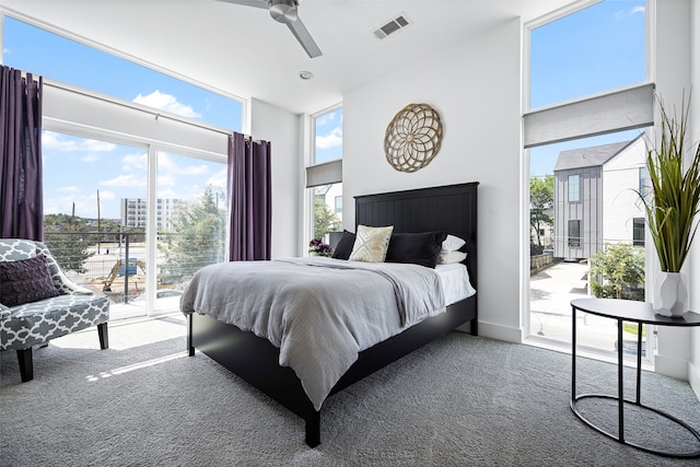 carpeted bedroom with a towering ceiling, access to outside, and ceiling fan