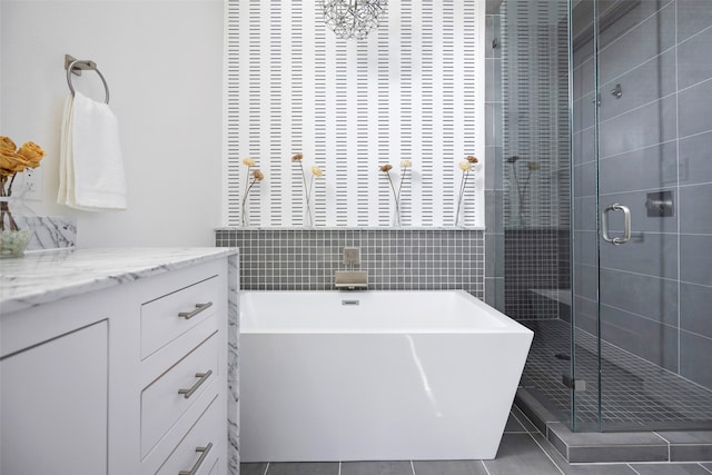 bathroom with vanity, backsplash, tile patterned floors, and separate shower and tub