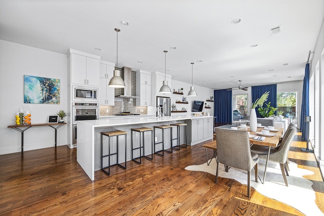 dining area featuring ceiling fan, sink, and dark hardwood / wood-style flooring