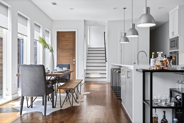 dining space featuring dark wood-type flooring and sink