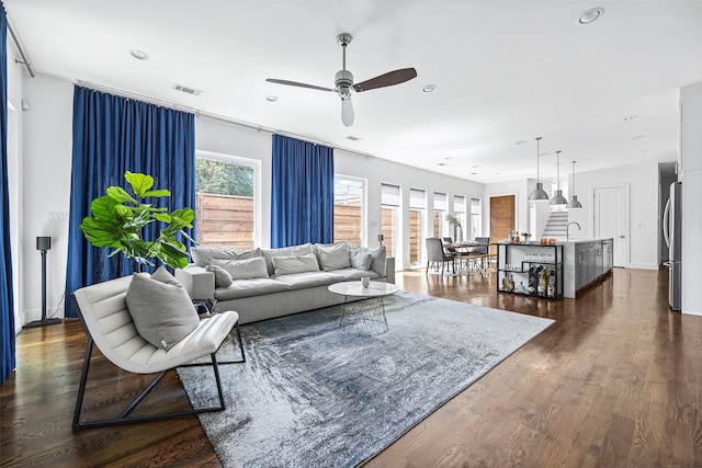 living room featuring sink, ceiling fan, a healthy amount of sunlight, and dark hardwood / wood-style flooring