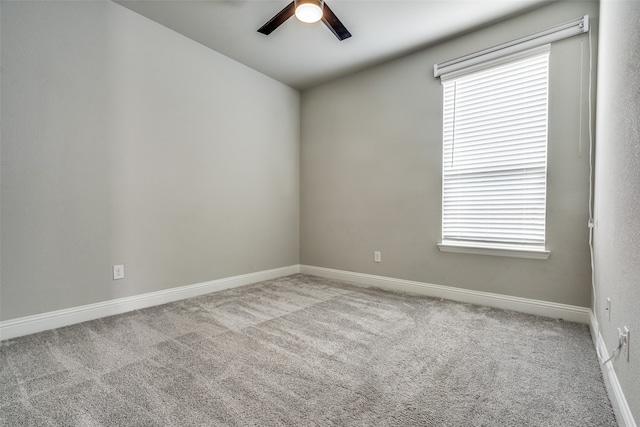 empty room featuring ceiling fan and light colored carpet