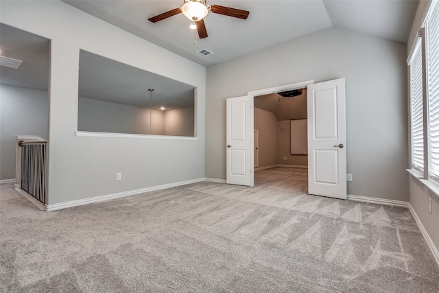 unfurnished bedroom with ceiling fan, lofted ceiling, and light colored carpet