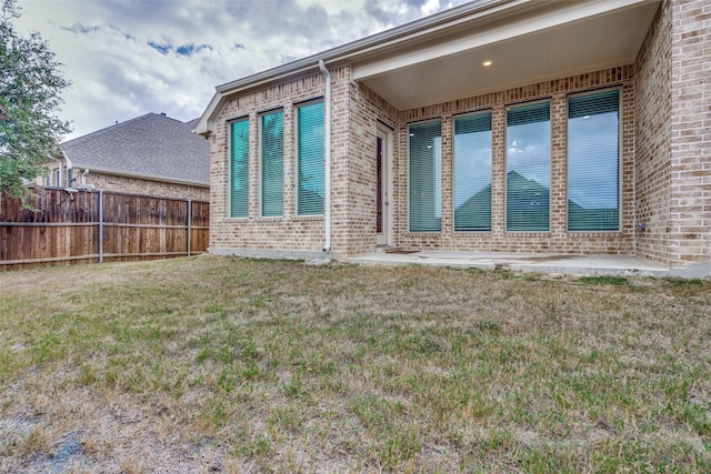 view of home's exterior with a patio and a lawn