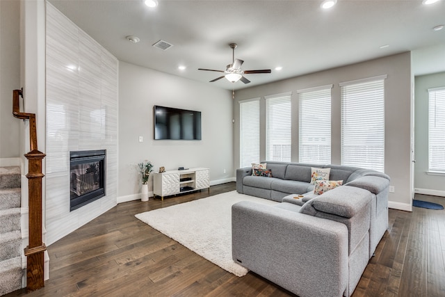 living room with a fireplace, dark hardwood / wood-style floors, and ceiling fan