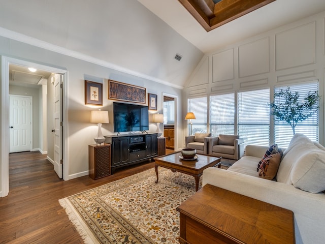 living room with crown molding, vaulted ceiling, and wood-type flooring