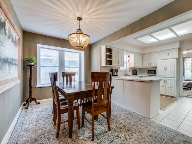 dining area featuring sink, a chandelier, and light tile patterned flooring