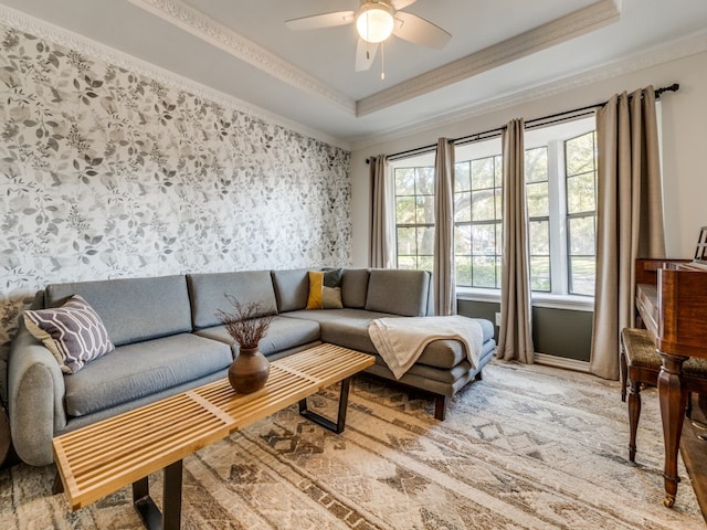 living room with crown molding, a raised ceiling, and ceiling fan