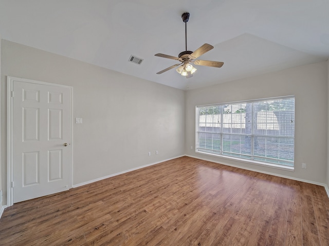 spare room featuring wood-type flooring, lofted ceiling, and ceiling fan