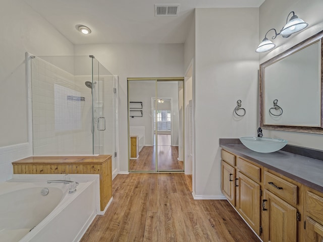 bathroom with hardwood / wood-style flooring, vanity, and separate shower and tub