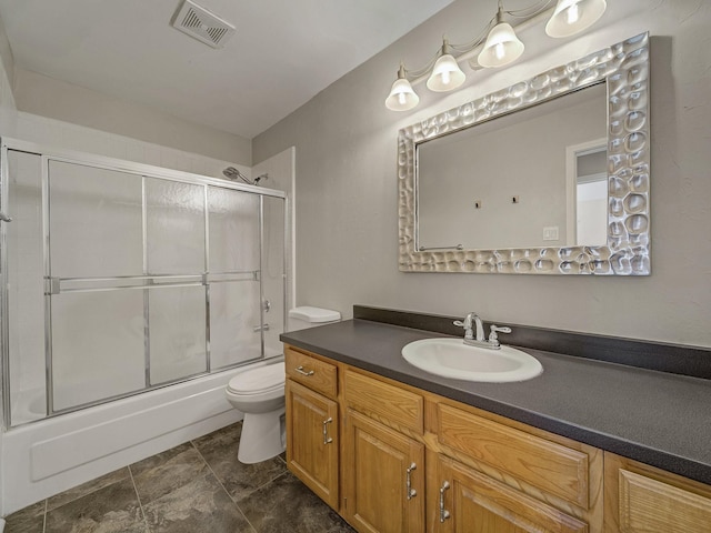 full bathroom with toilet, vanity, and shower / bath combination with glass door