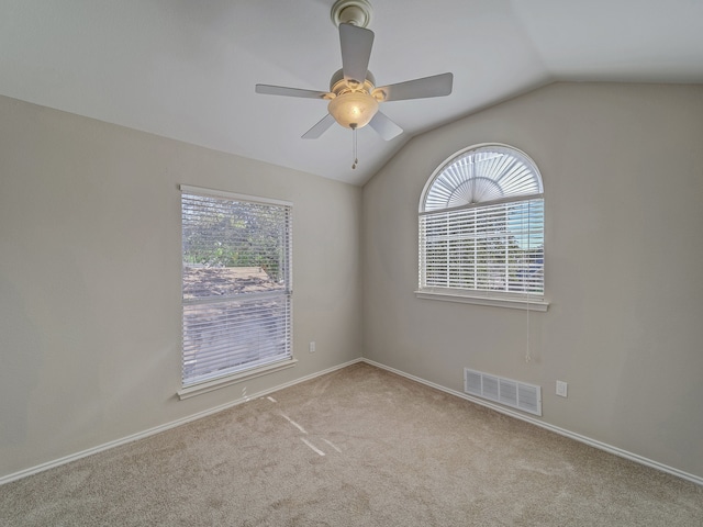 carpeted empty room featuring vaulted ceiling and ceiling fan