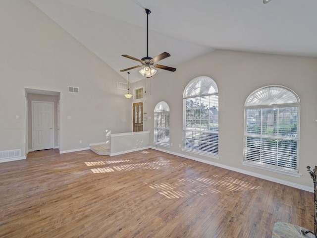 unfurnished living room with hardwood / wood-style flooring, ceiling fan, and high vaulted ceiling