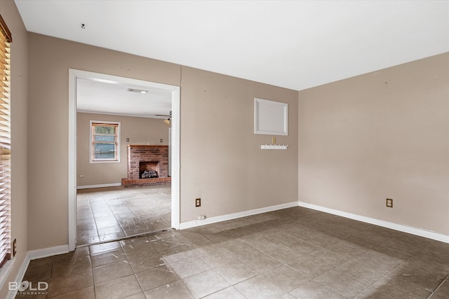 empty room featuring ceiling fan and a fireplace