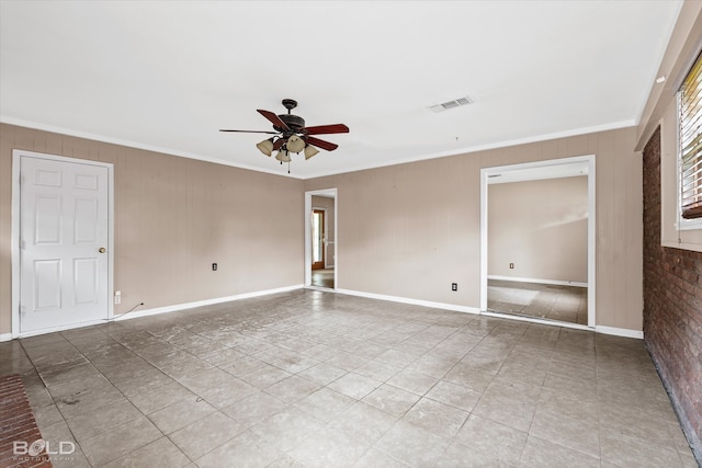 spare room with ornamental molding, wooden walls, and ceiling fan