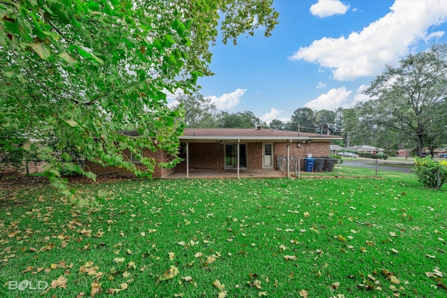 rear view of house featuring a patio area and a yard