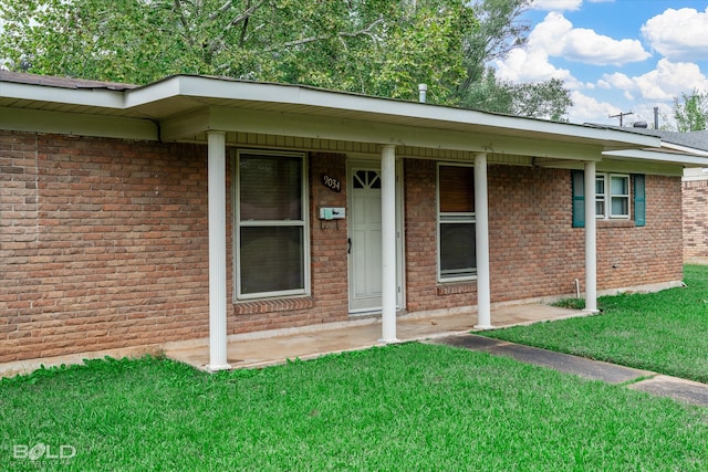 view of exterior entry with a lawn