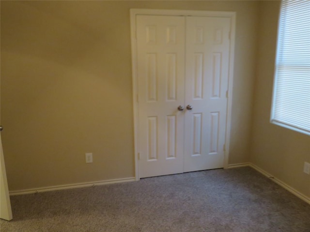 unfurnished bedroom with a closet and carpet flooring