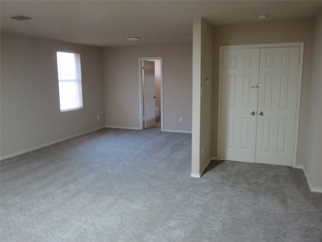 unfurnished bedroom featuring light carpet and a closet