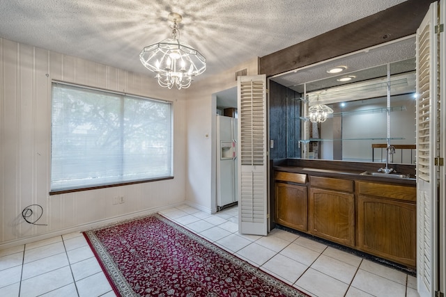 bathroom featuring vanity, a notable chandelier, a textured ceiling, and tile patterned flooring