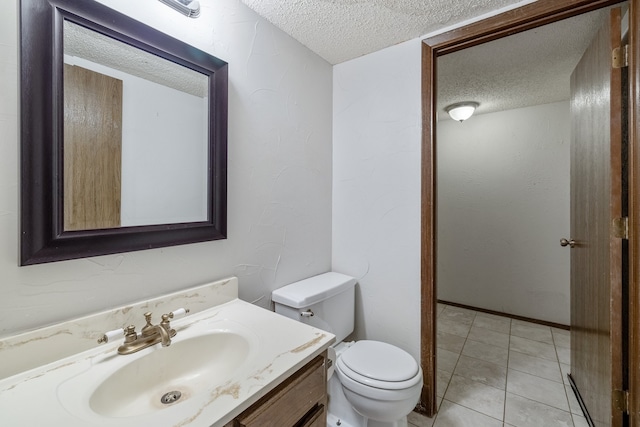 bathroom featuring vanity, a textured ceiling, toilet, and tile patterned floors