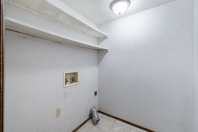 laundry area with hookup for an electric dryer, a textured ceiling, washer hookup, and light tile patterned floors