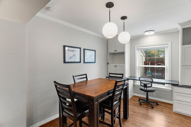 dining area featuring ornamental molding, built in desk, and light wood-type flooring