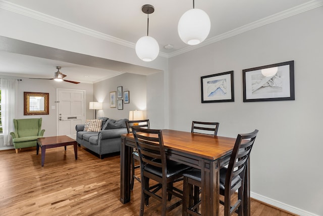 dining space with ceiling fan, hardwood / wood-style floors, and ornamental molding