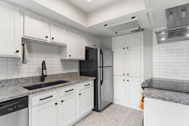 kitchen with sink, white cabinetry, stainless steel appliances, light stone countertops, and decorative backsplash