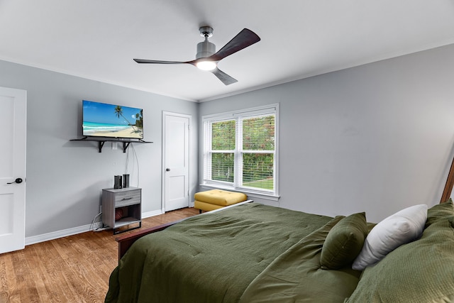 bedroom with hardwood / wood-style flooring, ceiling fan, and ornamental molding