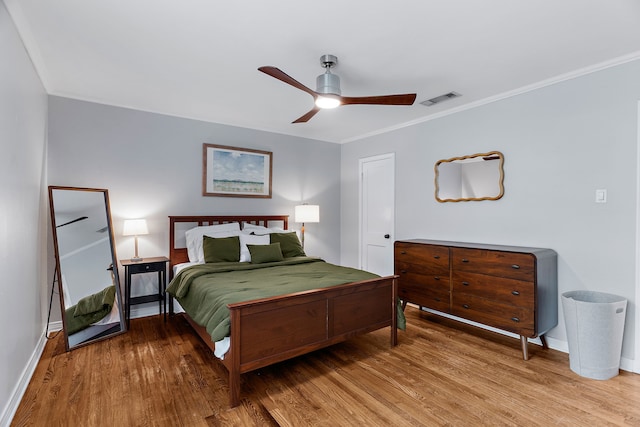 bedroom featuring ceiling fan, wood-type flooring, and ornamental molding