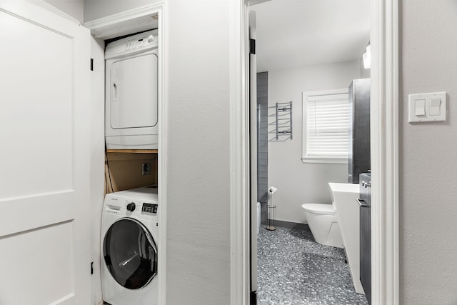 clothes washing area featuring stacked washer / dryer