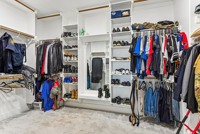 walk in closet with light carpet