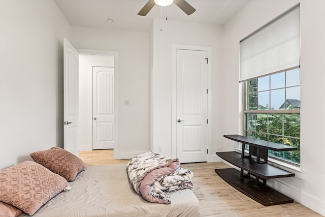 bedroom featuring multiple windows, light wood-type flooring, and ceiling fan