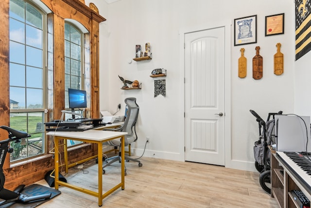 office with light hardwood / wood-style flooring and plenty of natural light