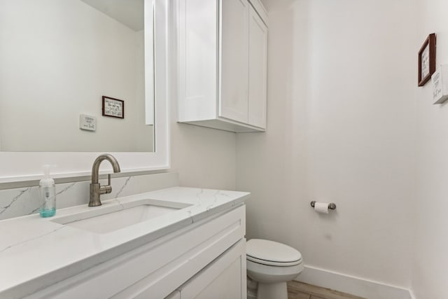 bathroom with vanity, hardwood / wood-style floors, and toilet